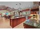Open concept gourmet kitchen offers a central island, stainless steel appliances, and tile flooring at 7025 Saddle Creek Cir, Sarasota, FL 34241