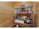 Pantry with wooden walls featuring metal shelves stocked with food, beverages, and household items at 7025 Saddle Creek Cir, Sarasota, FL 34241