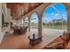 Covered patio area with tiled floor, outdoor seating, ceiling fans, and views of the pool and yard at 7025 Saddle Creek Cir, Sarasota, FL 34241