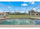 Screened pool with brick pavers overlooks fenced backyard with large trees, creating a private oasis at 7025 Saddle Creek Cir, Sarasota, FL 34241