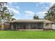 Spacious backyard featuring a screened-in porch, lush green grass, and tropical landscaping, perfect for outdoor living at 7401 3Rd Nw Ave, Bradenton, FL 34209