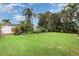 Lush green backyard providing ample space for outdoor activities and featuring a privacy fence and tropical plants at 7401 3Rd Nw Ave, Bradenton, FL 34209
