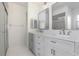 Bathroom featuring dual sinks, gray cabinets, white counters, and neutral tile at 7401 3Rd Nw Ave, Bradenton, FL 34209