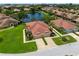 Aerial view of home, lawn, and landscaping near a tranquil community lake at 7403 Hamilton Rd, Bradenton, FL 34209