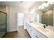 Bathroom featuring a double sink vanity with stone countertops and tiled walk-in shower at 7403 Hamilton Rd, Bradenton, FL 34209