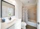 Bright bathroom with a modern vanity, a decorative mirror, and a shower/tub with nautical themed shower curtain at 7403 Hamilton Rd, Bradenton, FL 34209