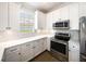 Bright kitchen with white cabinets, stainless steel appliances, herringbone backsplash, and stone countertops at 7403 Hamilton Rd, Bradenton, FL 34209