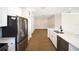 Open-concept kitchen with stainless steel refrigerator, stone countertops, and adjacent living area at 7403 Hamilton Rd, Bradenton, FL 34209