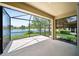 View from the screened lanai showcases a serene lake and well-maintained landscaping at 7403 Hamilton Rd, Bradenton, FL 34209