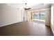 Bright living room with tile flooring and sliding glass doors leading to a screened lanai with a lake view at 7403 Hamilton Rd, Bradenton, FL 34209