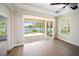 Bright living room offers wood floors, a modern ceiling fan, and an open door to the exterior patio at 7403 Hamilton Rd, Bradenton, FL 34209