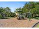 Community playground featuring a climbing wall, covered tower, and monkey bars, all set amongst mature trees at 7403 Hamilton Rd, Bradenton, FL 34209