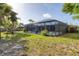 Expansive backyard features a screened pool enclosure, mature trees, and a manicured lawn at 7442 N Leewynn Dr, Sarasota, FL 34240
