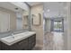 Bathroom featuring double sink vanity and access to the screened-in pool at 7442 N Leewynn Dr, Sarasota, FL 34240