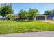Well-maintained home exterior with a manicured lawn, mature trees, and an attached garage at 7442 N Leewynn Dr, Sarasota, FL 34240
