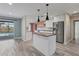 Modern kitchen featuring a center island, stainless steel appliances, and stylish pendant lighting at 7442 N Leewynn Dr, Sarasota, FL 34240