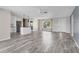 Spacious living area with wood-look flooring, ceiling fan, and abundant natural light at 7442 N Leewynn Dr, Sarasota, FL 34240