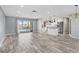 Bright, open-concept living area featuring wood-look flooring and sliding glass doors to the pool at 7442 N Leewynn Dr, Sarasota, FL 34240