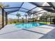 Beautiful in-ground pool surrounded by a screened enclosure, landscaping, and a deck area at 7442 N Leewynn Dr, Sarasota, FL 34240