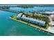 Aerial view of waterfront condo buildings with boat docks, green lawn, and mature trees along the Sarasota Bay at 767 John Ringling Blvd # 25, Sarasota, FL 34236