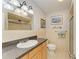 Tiled bathroom with a granite countertop vanity, decorative accents, and glass enclosed shower at 767 John Ringling Blvd # 25, Sarasota, FL 34236