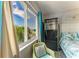 Bright bedroom with a view featuring a large window, comfortable chair and tropical accents at 767 John Ringling Blvd # 25, Sarasota, FL 34236