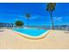 Community pool with palm trees and beautiful water views on a sunny day at 767 John Ringling Blvd # 25, Sarasota, FL 34236