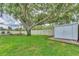 Expansive backyard with lush green grass, a large shade tree, and a privacy fence at 7727 9Th Avenue Nw Dr, Bradenton, FL 34209