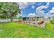 Expansive backyard with lush green lawn, landscaped garden bed, and screened-in lanai creating a peaceful retreat at 7727 9Th Avenue Nw Dr, Bradenton, FL 34209