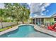 Beautiful backyard with a sparkling pool, covered patio, lush landscaping, and ample space for outdoor activities at 7727 9Th Avenue Nw Dr, Bradenton, FL 34209