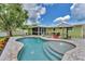 Expansive backyard with a sparkling pool, covered patio, and lush landscaping, perfect for outdoor living at 7727 9Th Avenue Nw Dr, Bradenton, FL 34209