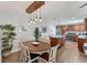 Open dining room with wood floors, modern lighting, and a view into the kitchen and island at 7727 9Th Avenue Nw Dr, Bradenton, FL 34209