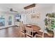 Bright dining room featuring modern lighting, wood floors, and direct access to the backyard through glass doors at 7727 9Th Avenue Nw Dr, Bradenton, FL 34209