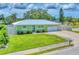 Charming single story home featuring a metal roof, lush lawn and beautiful landscaping at 7727 9Th Avenue Nw Dr, Bradenton, FL 34209