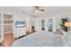Bright main bedroom featuring wood floors, ceiling fan, and private access to the outdoor area at 7727 9Th Avenue Nw Dr, Bradenton, FL 34209