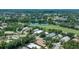 Aerial view of property featuring golf course and lake views, surrounded by lush trees at 7952 Hampton Ct, University Park, FL 34201