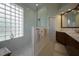 Modern bathroom boasts a glass shower, block glass window, and a double sink vanity at 7952 Hampton Ct, University Park, FL 34201