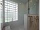 Modern bathroom featuring a large glass shower, with a window block and marble walls at 7952 Hampton Ct, University Park, FL 34201