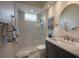 Modern bathroom features a glass-enclosed shower, marble countertops, and a stylish round mirror at 7952 Hampton Ct, University Park, FL 34201