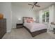 Inviting bedroom features a comfortable bed, neutral decor, ceiling fan, and a view through the bright window at 7952 Hampton Ct, University Park, FL 34201