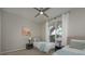 Bright bedroom featuring twin beds, neutral decor, ceiling fan, and a large window offering natural light at 7952 Hampton Ct, University Park, FL 34201