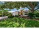 Charming single-story home with lush landscaping, mature trees, and well-maintained lawn at 7952 Hampton Ct, University Park, FL 34201