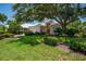 Charming home with a lush green lawn and mature trees providing ample shade on a sunny day at 7952 Hampton Ct, University Park, FL 34201