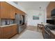 Well-lit kitchen with wood cabinets, stainless steel appliances, and an adjacent dining area at 7952 Hampton Ct, University Park, FL 34201
