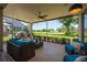 Relaxing screened lanai with comfortable seating and view of the lush backyard and golf course at 7952 Hampton Ct, University Park, FL 34201