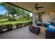 Cozy lanai with comfortable seating, ceiling fan, and view of tropical landscaping and golf course at 7952 Hampton Ct, University Park, FL 34201