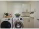 Efficient laundry room featuring modern appliances, ample counter space, and storage cabinets at 7952 Hampton Ct, University Park, FL 34201
