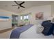 A cozy main bedroom with light walls features a flat screen tv and a view of the backyard at 7952 Hampton Ct, University Park, FL 34201