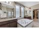 Primary bathroom featuring separate vanities, a soaking tub, and glass shower at 843 Molly Cir, Sarasota, FL 34232