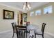 Cozy dining area with a round table, four chairs, decorative chandelier, and natural light from the windows at 843 Molly Cir, Sarasota, FL 34232